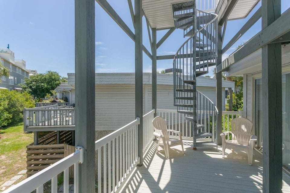 Deck with spiral staircase, white railing, and seating