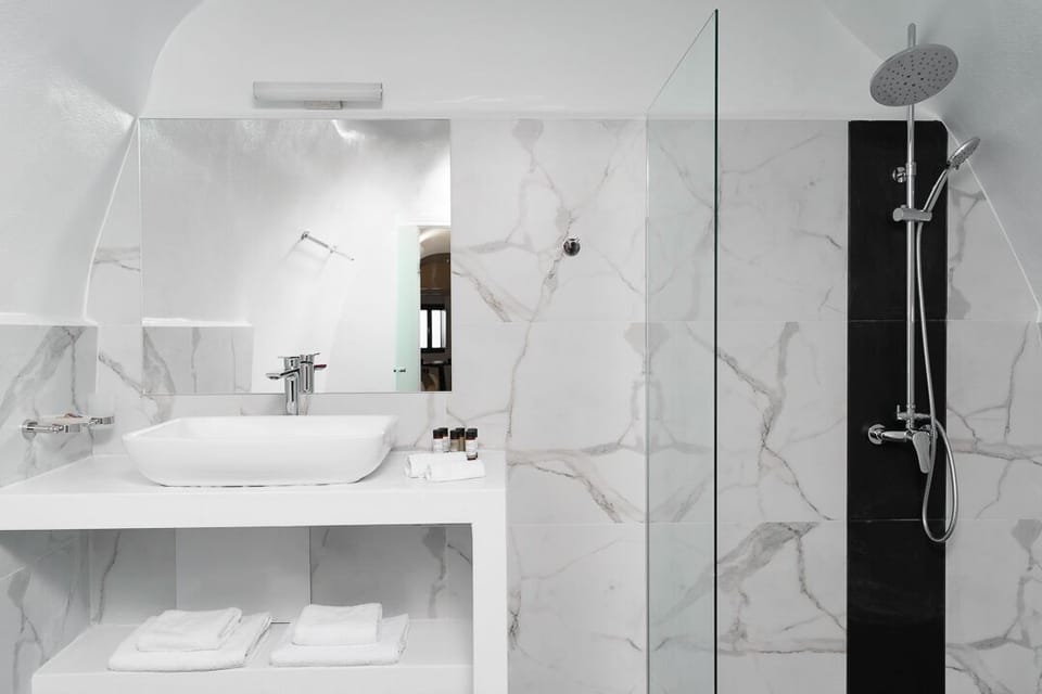 Junior Suite (Caldera View) | Bathroom | Shower, free toiletries, hair dryer, bathrobes