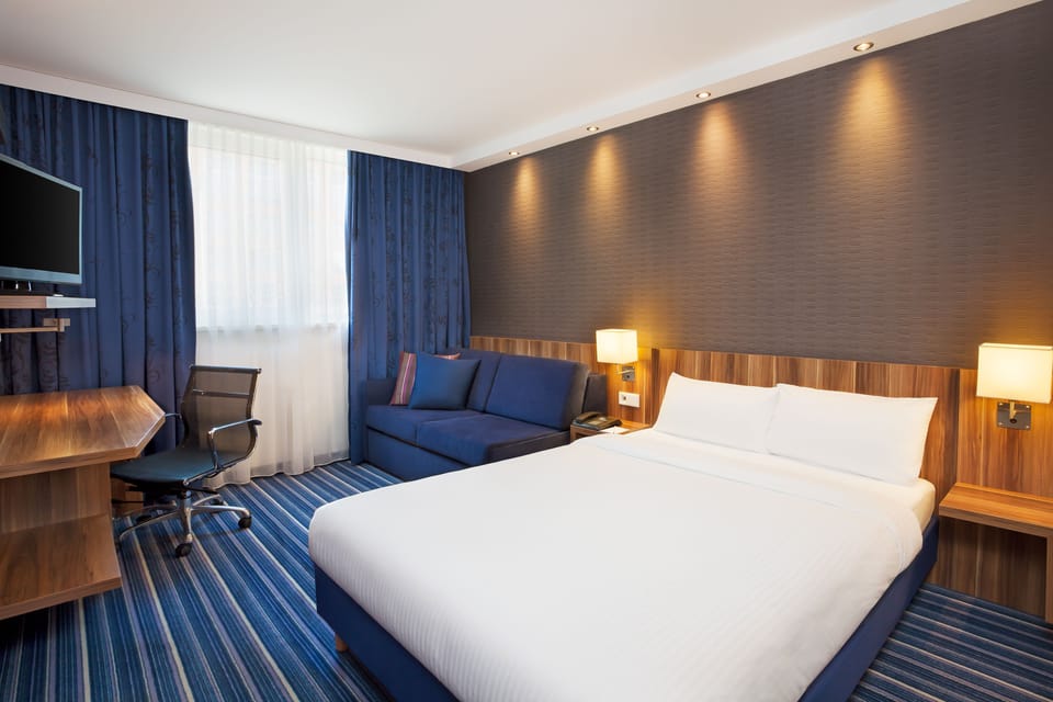 Hypo-allergenic bedding, desk, laptop workspace, blackout drapes
