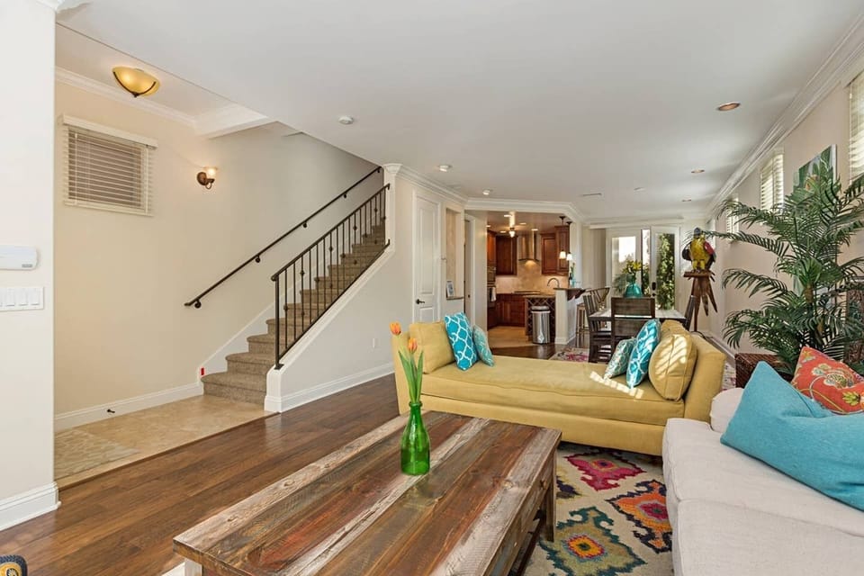 Yellow day bed separates the living room from the open dining area.