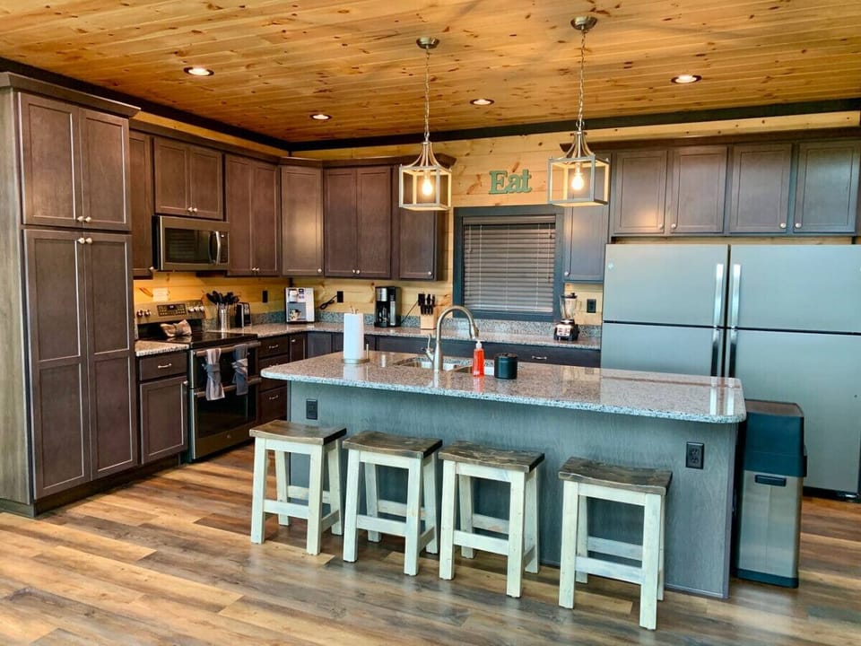 There is more seating at the kitchen island which contains a sink and dishwasher.
