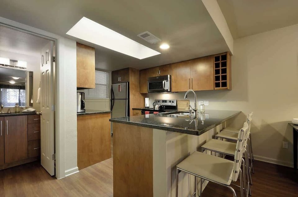 Kitchen area (complete with a sink, countertop, fridge, microwave, stove, utensils, coffee maker)