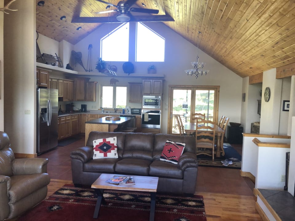 Large great room with tongue in groove ceilings opens into large kitchen. 
