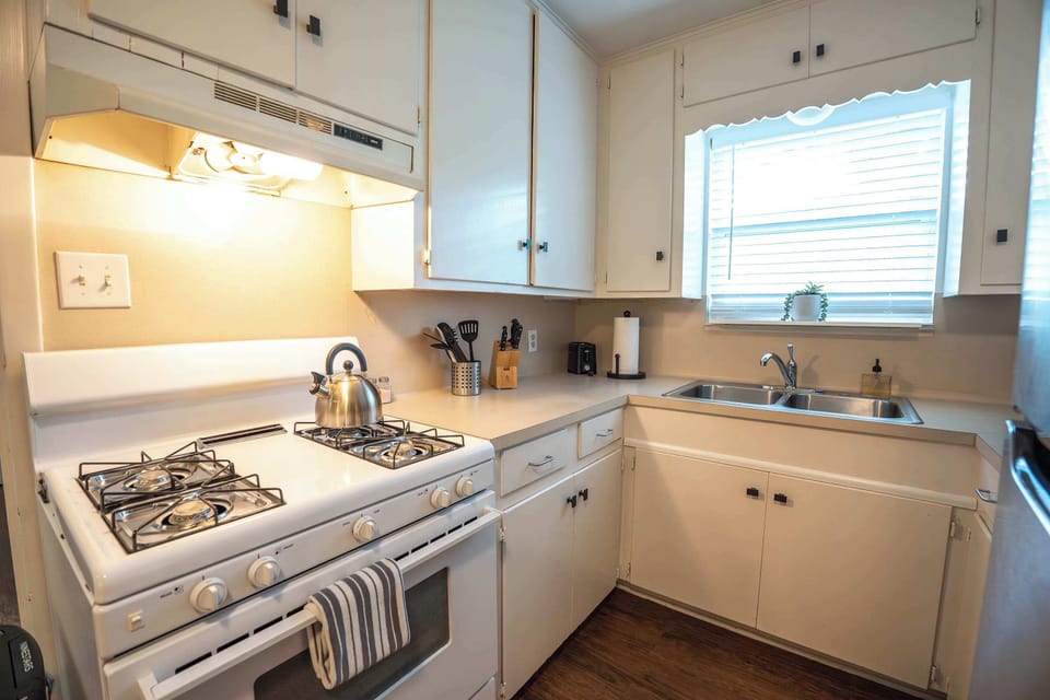 The kitchen is stocked with dishes and appliances to make meals at home.