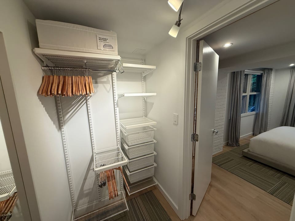 Walk-in closet w/custom Elfa system, wood hangers, drawers, + queen air mattress