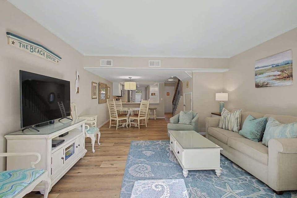 Relax in your coastal living space with comfortable seating, beachy blues, and entertainment center - perfect for unwinding.