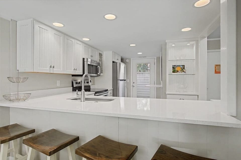 Your bright, open kitchen features gleaming countertops and modern appliances, perfect for whipping up morning coffee or preparing meals together.