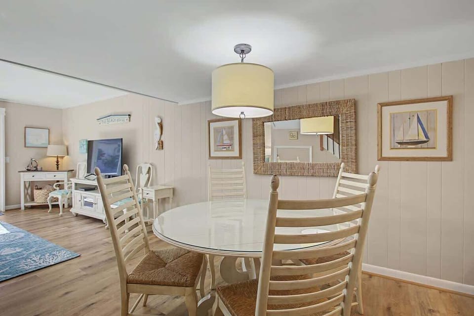 Relax in your coastal-inspired dining space with nautical artwork and warm wood accents creating the perfect atmosphere for memorable meals.