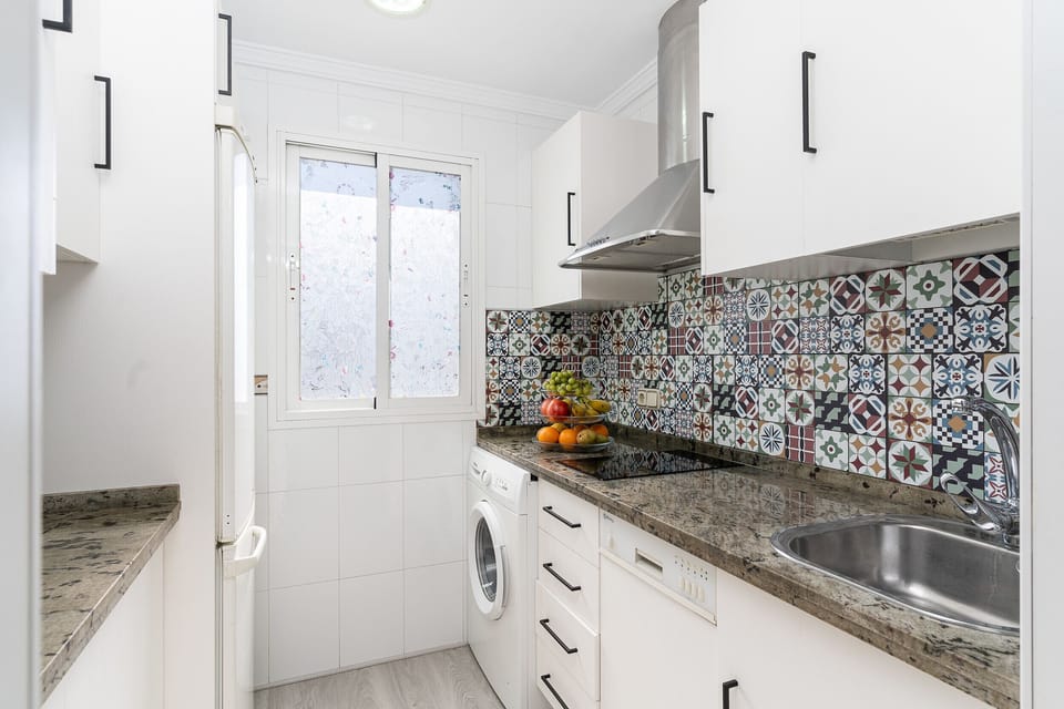 Functional modern kitchen with granite countertops and washing machine