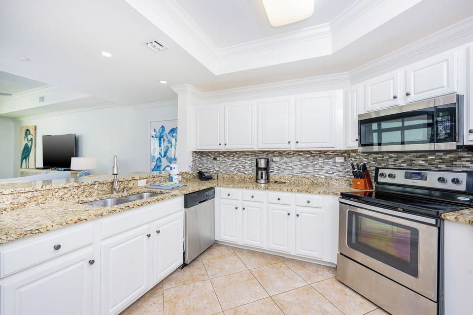 This modern kitchen features stainless appliances, granite countertops, and a convenient coffee maker for your morning brew