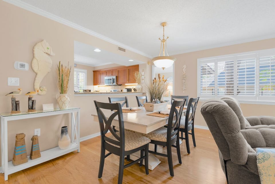 Dining area has plantation shutters, hardwood floors.
