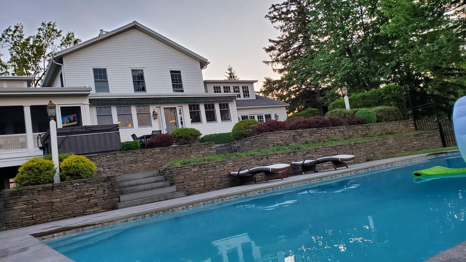 Another look from the pool to the house, fire pit, hot tub and screen porch