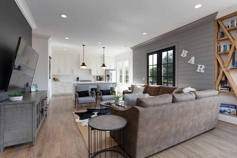 A bedroom with a dark accent wall and warm lighting creates a cozy, hotel-like atmosphere.