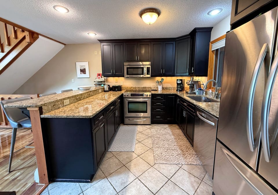 The renovated kitchen features stainless steel appliances, and granite countertops.