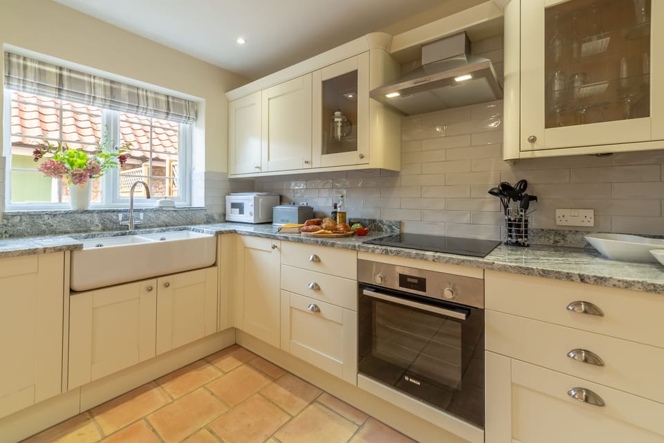 Ground floor: Kitchen with double Belfast sink, electric cooker and hob, microwave, fridge/freezer and dishwasher
