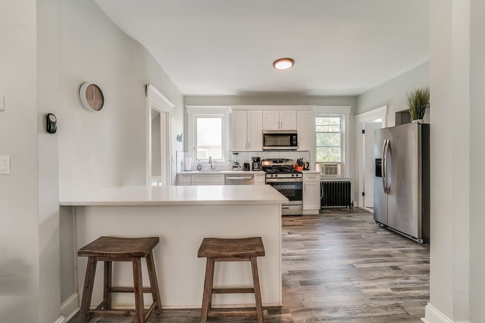 Kitchen with island (and 2 barstools) open to Living Room