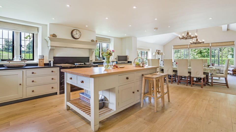The spacious kitchen has an island and dining table seating ten, perfect for family meals
