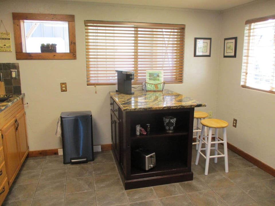 Kitchen island with Keurig, toaster and seating.