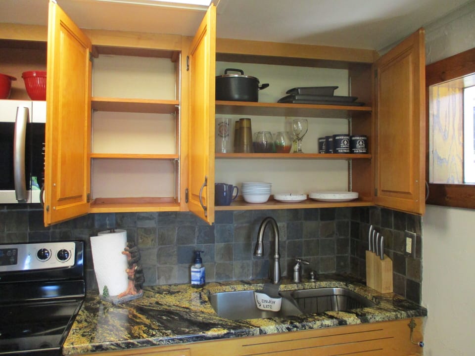 Kitchen cabinets with an empty one for guests use.