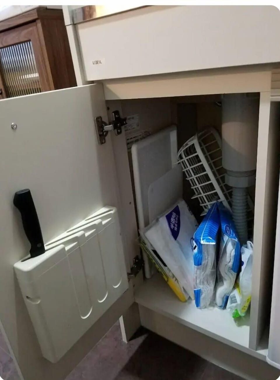 Kitchen knife on the door, cleaning tools under the sink