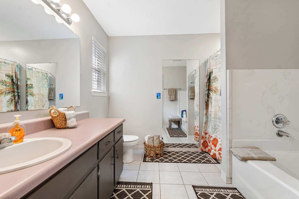 Sparkling bathroom with large mirror and tub.