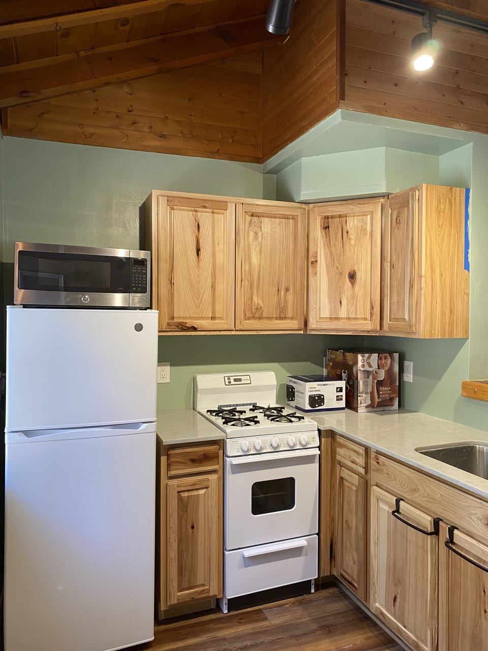 Well stocked kitchen with pots, pans, baking dishes, plates/bowls and silverware