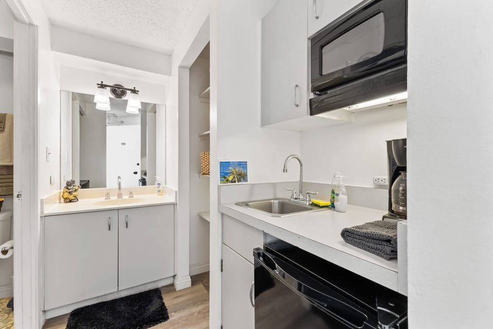Microwave, mini fridge, blender, rice cooker, coffeemaker, dishes, and flatware.