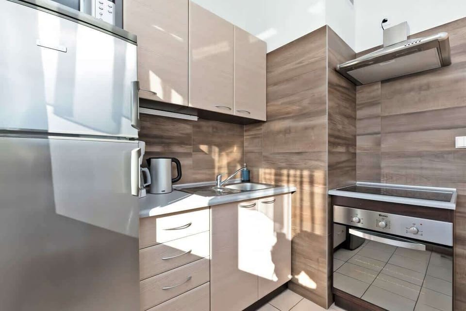 A modern kitchen with cabinets and stainless steel appliances. The interior is functional and well-lit.