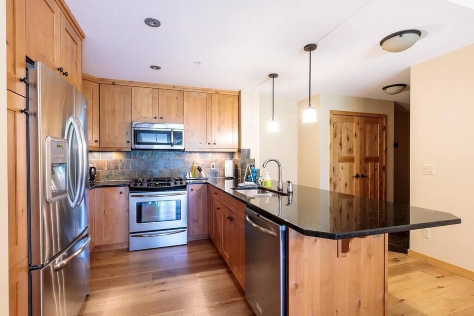 Chefs kitchen with granite countertops, stainless appliances, and loads of bench space