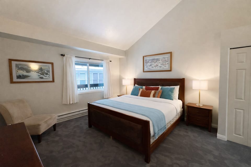Peaceful guest bedroom featuring a comfortable bed, ceiling fan, and lovely artwork. A tranquil retreat for a restful stay in the mountains.