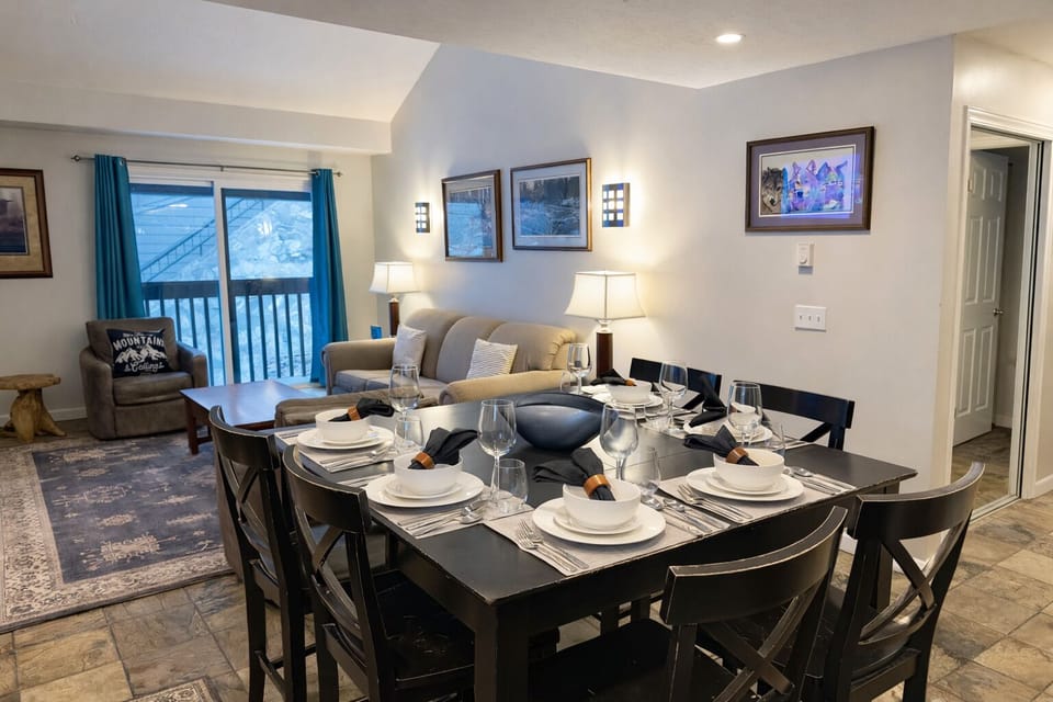 Gather around your beautifully set dining table, perfectly positioned between the cozy living area and your private balcony with mountain views.
