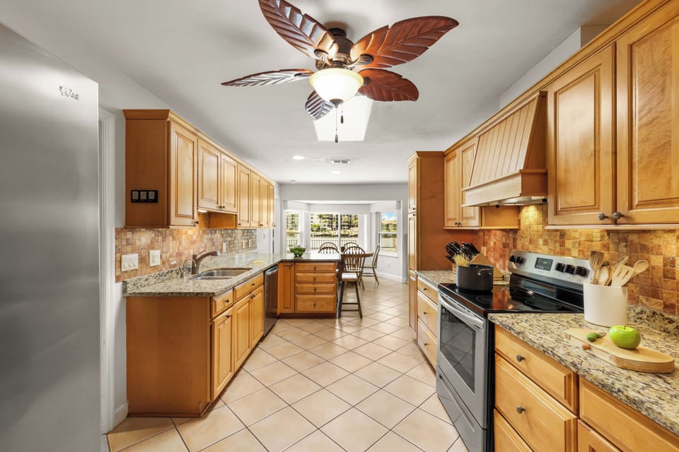 Open kitchen with wood cabinetry and stainless appliances.