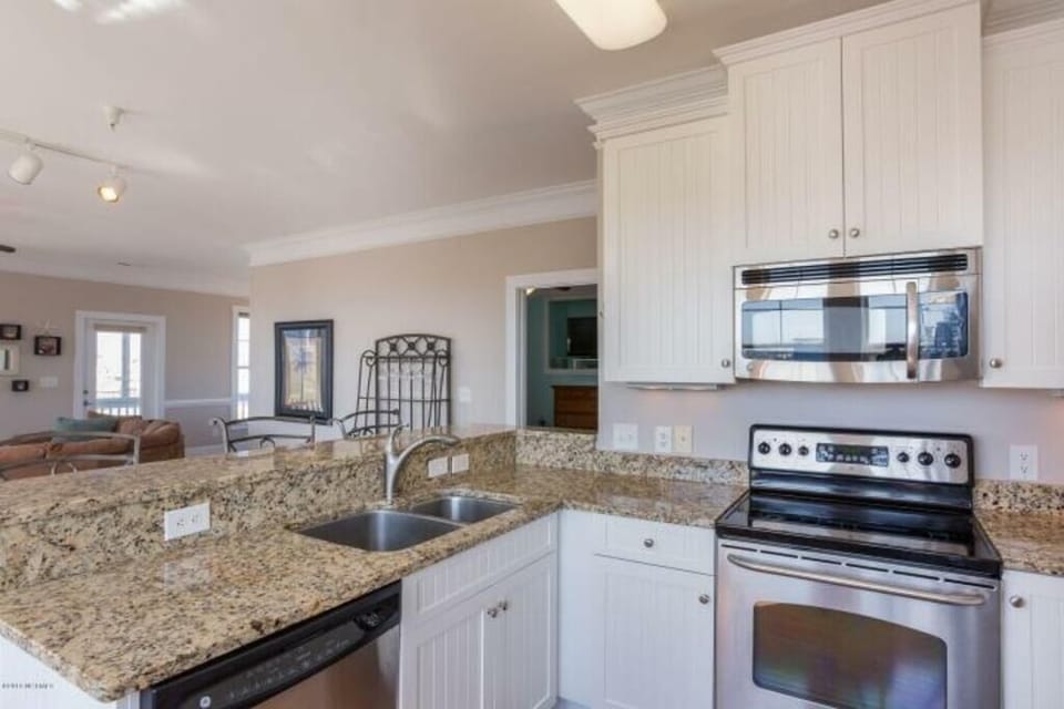 Spacious kitchen with granite counter tops and bar area.