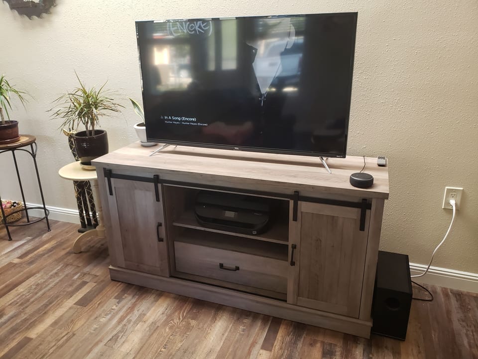 Roku 50" TV with A DVD player and HP printer.