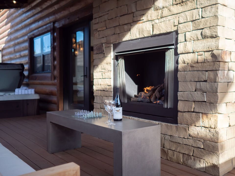 Outdoor patio with fireplace and private hot tub
