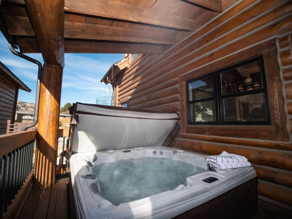 Outdoor patio with hot tub and fireplace