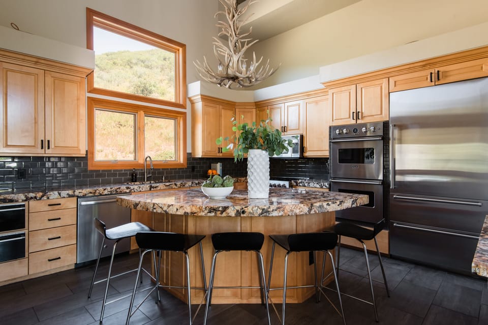 Large kitchen features high end appliances, and an island with countertop stool seating.