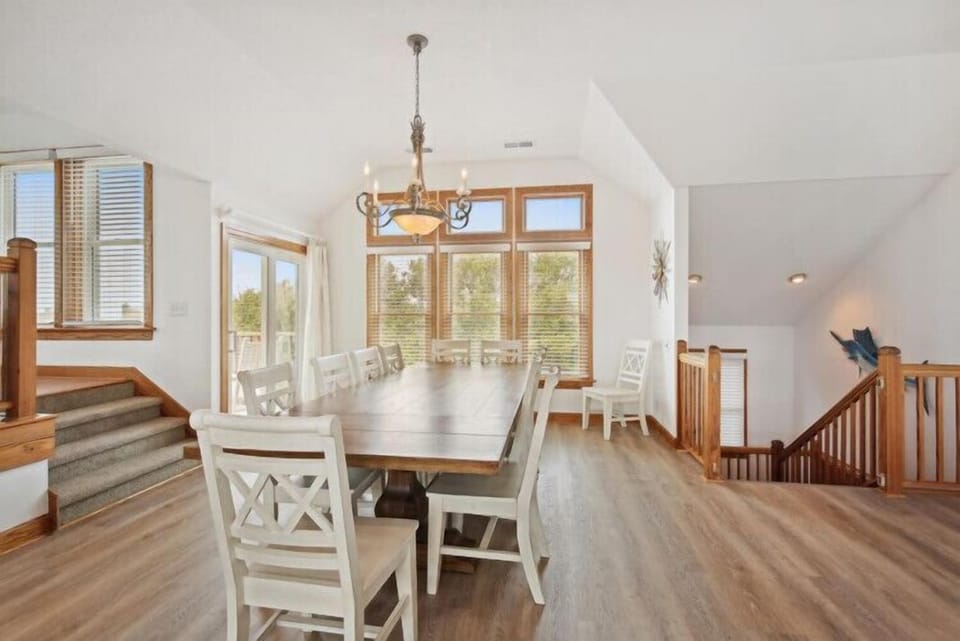Gather around this elegant dining table with room for the whole family, flooded with natural light from large windows overlooking the surrounding landscape. Your home away from home awaits.