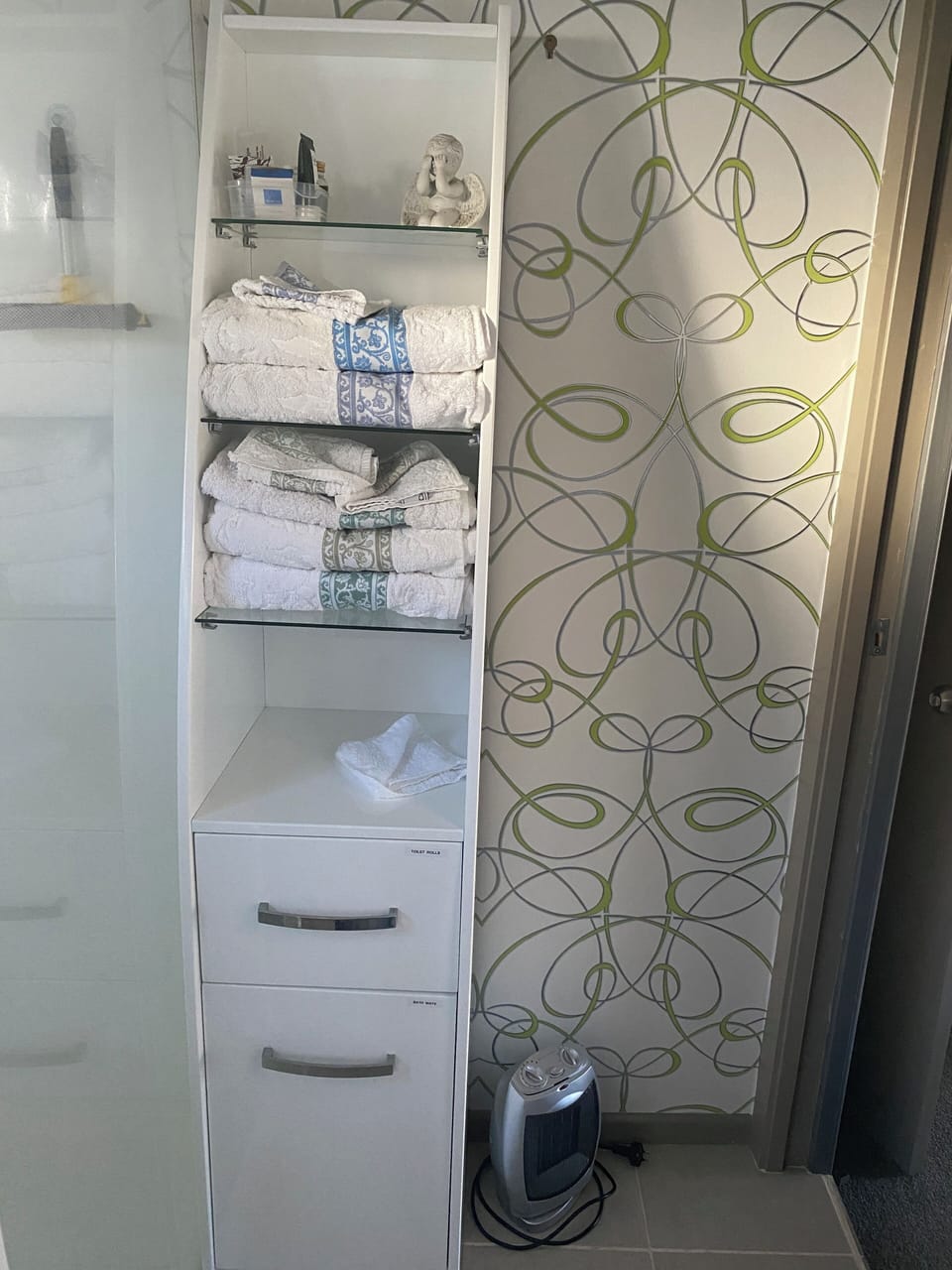 Shelving with heaps of towels and bathroom accessories