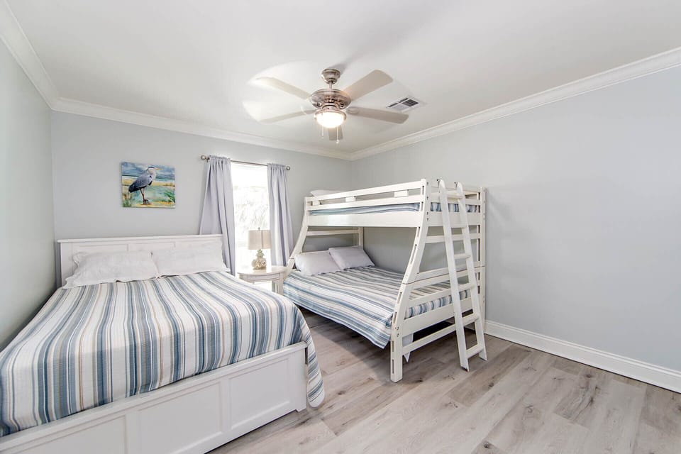 This room has a queen size bed. A set of bunks that has a twin top and a full size on the bottom. All linens provided.