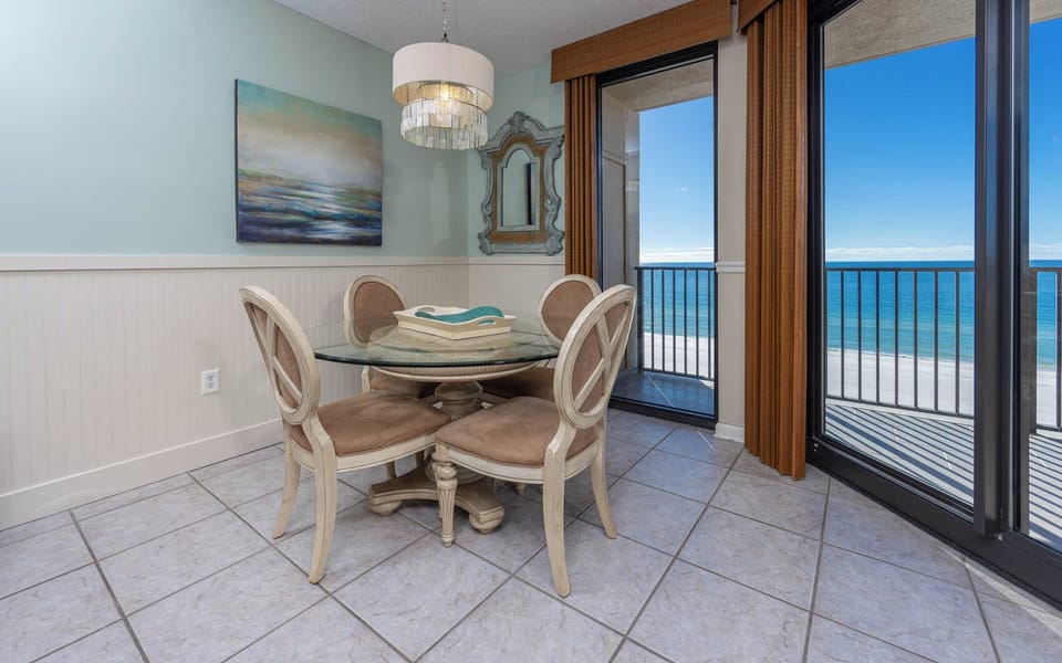 Dine at the glass table while enjoying views of the calm waters and the inviting beach just beyond the sliding doors