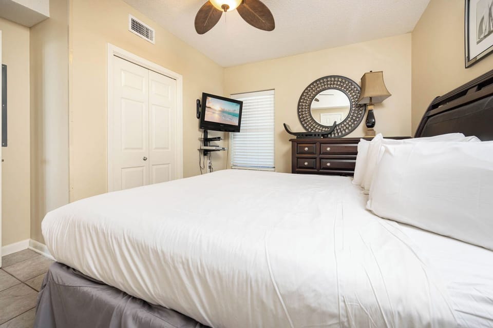 Relax in the comfortable master bedroom featuring a plush king bed, flat-screen TV, and tasteful decor for a restful stay