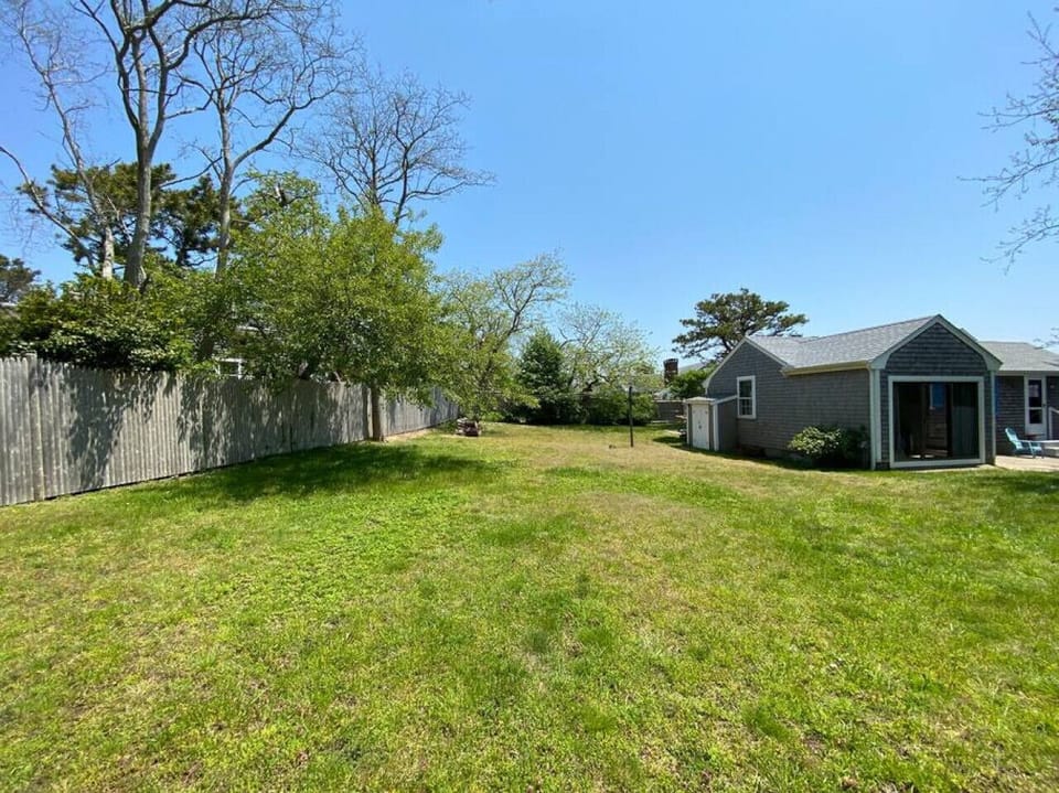 View towards the primary bedroom with sliding doors that open to the spacious partially-fenced backyard, perfect for outdoor games.