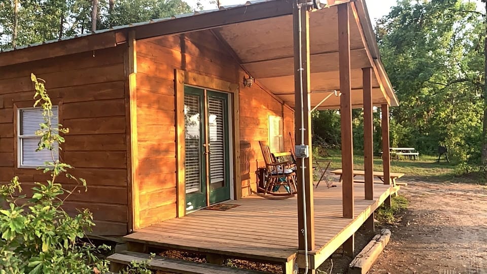 Closer up view of cabin and porch which overlooks the water