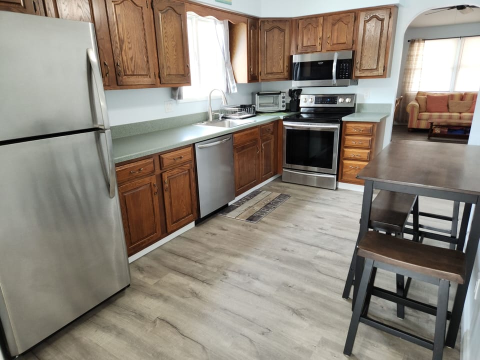 Kitchen with updated SS appliances and new vinyl floor. 