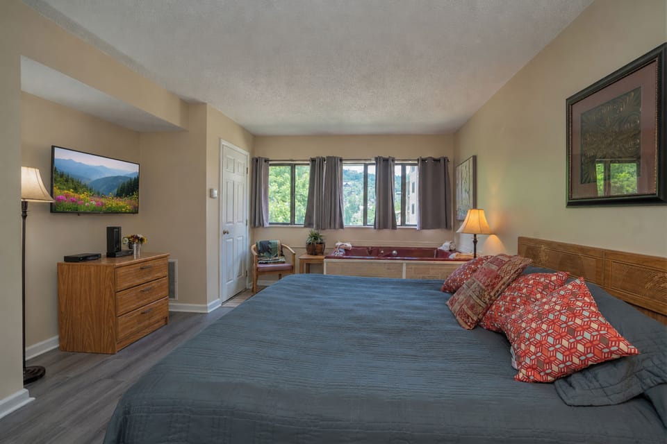 Your spacious retreat features calming tones, plush bedding, and natural light pouring through large windows. Unwind in the private hot tub after a day exploring the area, and enjoy modern comforts like a flat-screen TV and cozy seating nook.