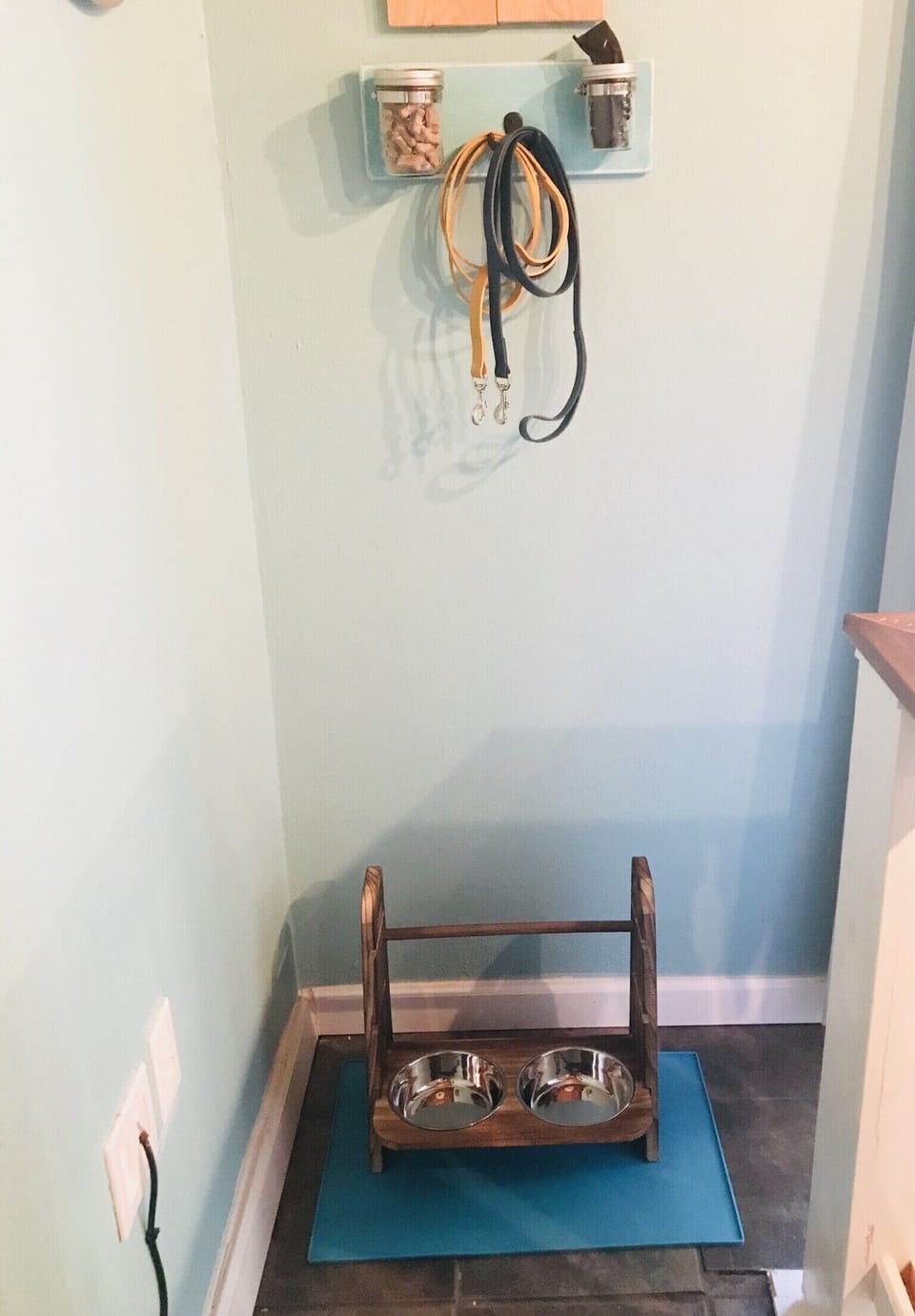 Pet station with food and water bowl stand, leashes, treats and pet waste bags 
