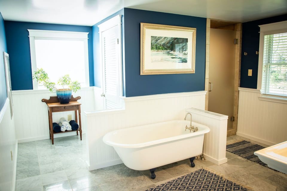 Upstairs bathroom with large walk-in shower, claw foot tub & river views.