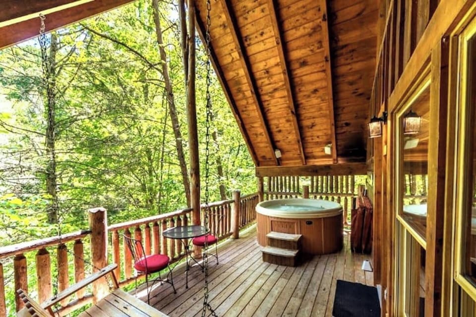 Back deck with a view, swing, sitting area, and hot tub!