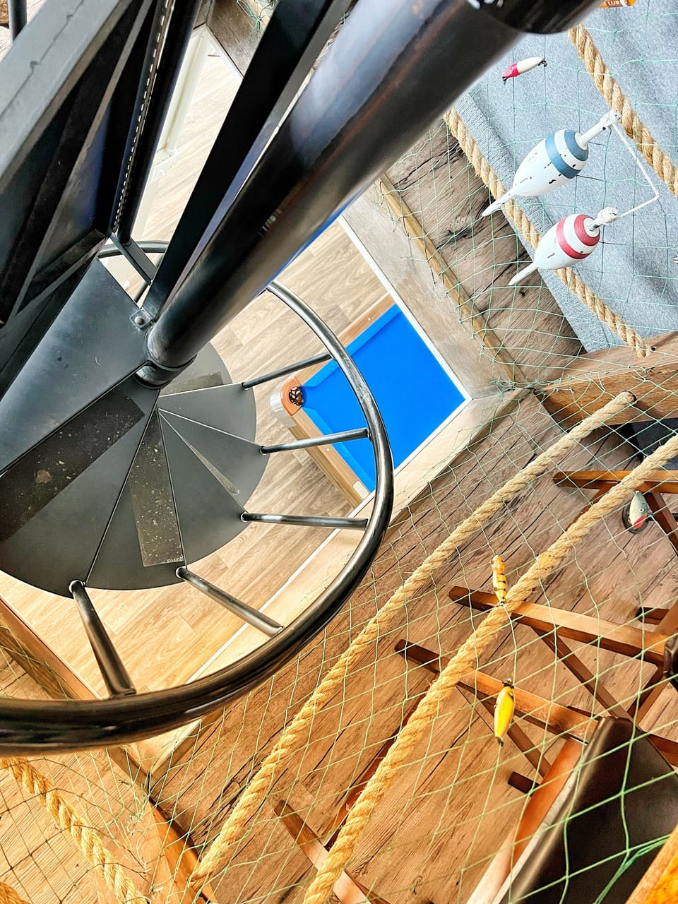 Spiral staircase in the center of the unique hexagon cottage. Pool table below. 